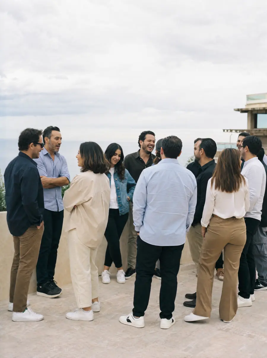 Un equipo de trabajo conversa de pie en la terraza de un hotel durante un viaje de empresa
